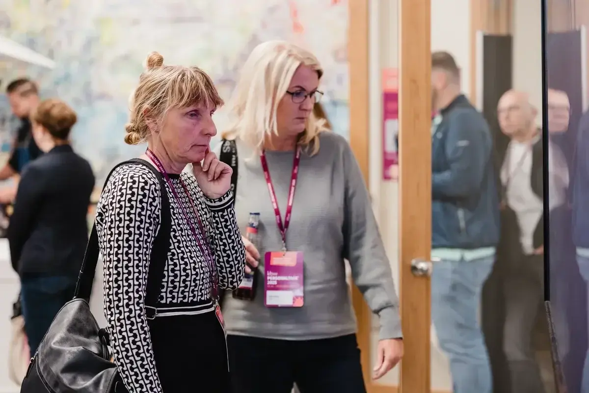 Zwei Teilnehmerinnen studieren das digitale Seminarprogramm