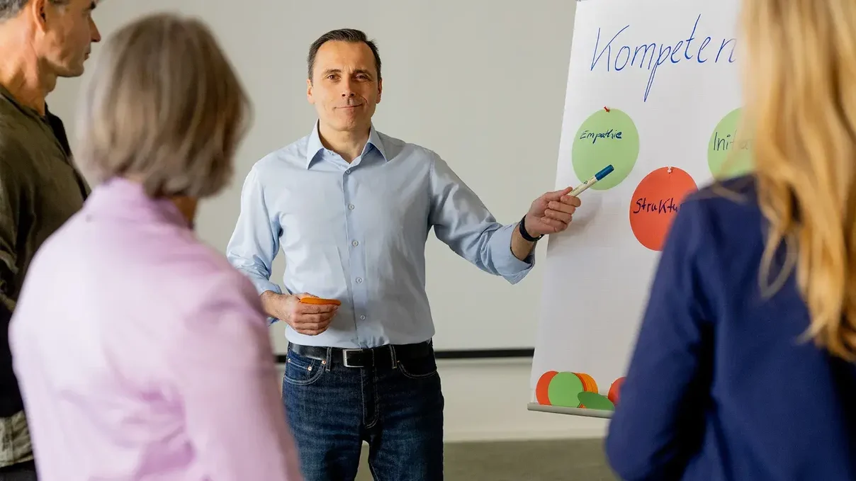 Ein Mann vor einem Flipchart, der referiert.